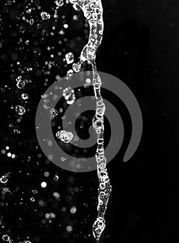 Water jet with spray on a black background