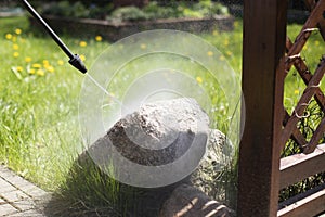 Water jets from the high-pressure washer cleaning rocks in the garden