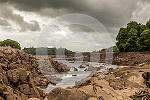 Water of Ken River flowing through a rocky gorge into a drained Earlstoun Dam