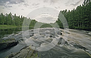 Water landscape with clouds, forest and rift