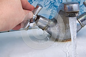 Water leaking from a rusty old faucet in the bathroom