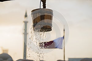 Water leaks from a wooden bucket on an old well in Doha,Qatar.