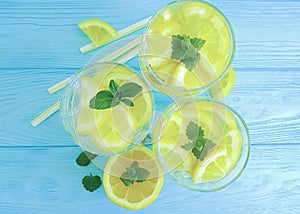 Water with lemon, mint on a wooden background