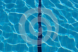 Water lens to pool bottom. Blue line in swimming pool. Sunlight on water in pool. Sun glare in swimming pool