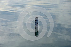 Water level indicator show the depth of water in a lake, water depth sign on calm water surface