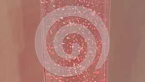 Water level rising in glass tube, red liquid and air bubbles