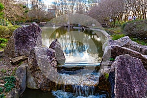 Water from man made lake or pond flowing into a small rapid or fall, Hermann Park Houston Texas, USA