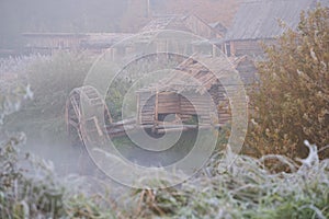 water mill in autumn fog with the first frost