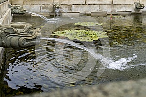 Water Outlet, Waterfall Spillway with Chinese Creature Sculpture in a Traditional Chinese Garden Pond, Eye Level View