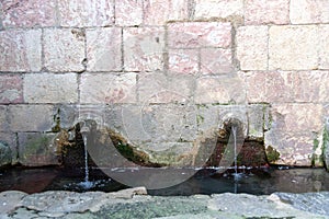 Water outlets in a wall from a spring