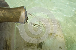 Water permanently flowing from a pipe of a public fountain photo