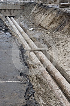 Water pipes in ground during plumbing construction site pit trench ditch