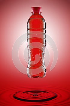 Water in a plastic botlle on a red background