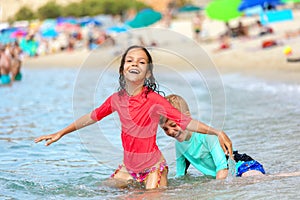 Water play with two happy children having fun at beach, Friendship concept with smiling boy and girl enjoying time together