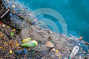 Water pollution old garbage and oil patches on water surface