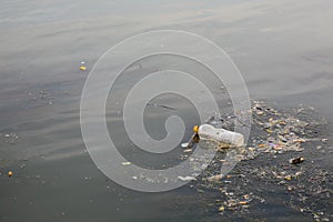 Water pollution - plastic bottle on river surface