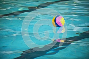 A water polo ball floating on the water in a pool