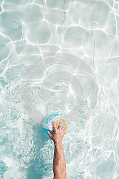 Water polo player with a ball in a blue pool water. Top view. Copy space
