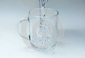 Water is poured into a glass cup