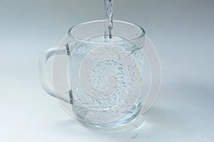 Water is poured into a glass cup,