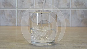 Water is poured into a glass glass Cup