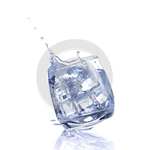 Water is poured into a glass with ice cubes