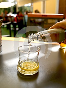 Water is poured into a glass on a table in a cafe