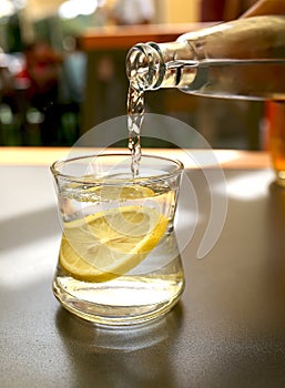 Water is poured into a glass on a table in a cafe