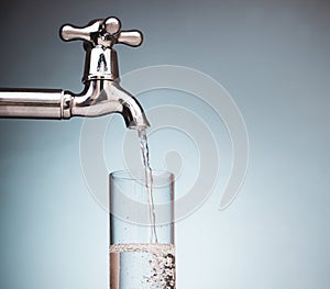 Water is poured into a glass from the tap