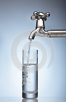 Water is poured into a glass from the tap