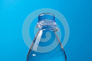 Water is poured out and a plastic bottle on a blue background.