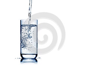 Water pouring into glass with bubbles and reflection isolated on white