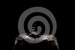 Water pouring into glass isolated on black background