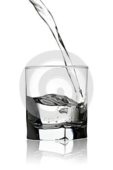 Water pouring into a glass with reflection isolated on white