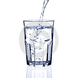 Water pouring into glass on white background