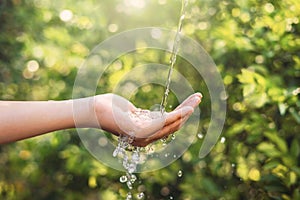 Water pouring on hand in morning ligth background