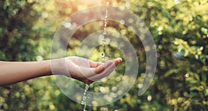 Water pouring on hand in morning ligth background