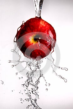 Water pouring off red apple.