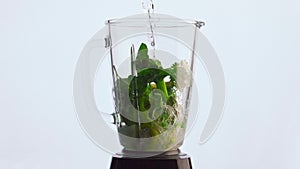 Water pouring vegetable blender super slow motion close up. Fresh veggies fruits