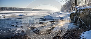 Water pours from the the waste-pipe into the river in winter