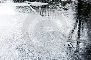 Water puddles with raindrops falling on wet asphalt