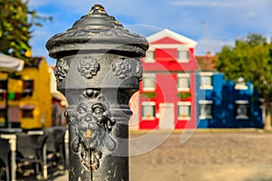 Water pump and colorful houses in Burano island near Venice Ital