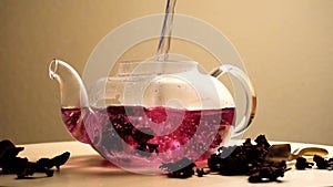 Water puring in teapot with red karkade tea