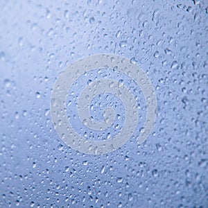 Water rain drops on blue glass surface as background. Abstract backdrop.