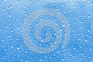 Water rain drops on blue glass surface as background. Abstract backdrop.