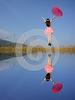 Water Reflection Happy Woman Jumping with blue sky