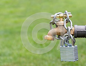 Outdoor water faucet with lock and chain.