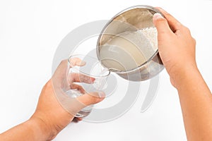 Water from rice rinse poured into a glass to be used as natural fertilizer