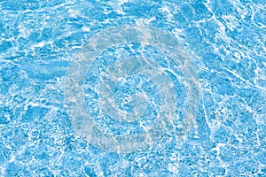 Water rippled and sunny reflections in swimming pool surface background