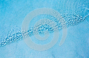 Water ripples on blue tiled swimming pool background